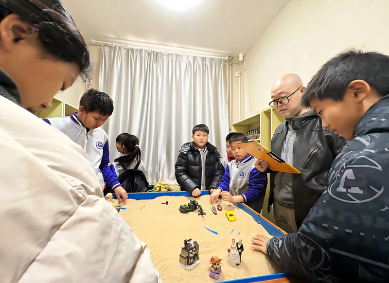 8优秀党员教师周相有（右二）为青少年进行心理健康沙盘服务.jpg